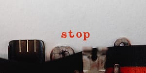 red stop word coming out of a typewriter
