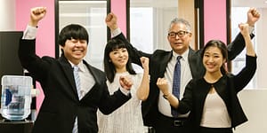 a group of people raising hands in the office
