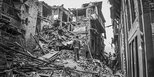 people looking at wrecked buildings